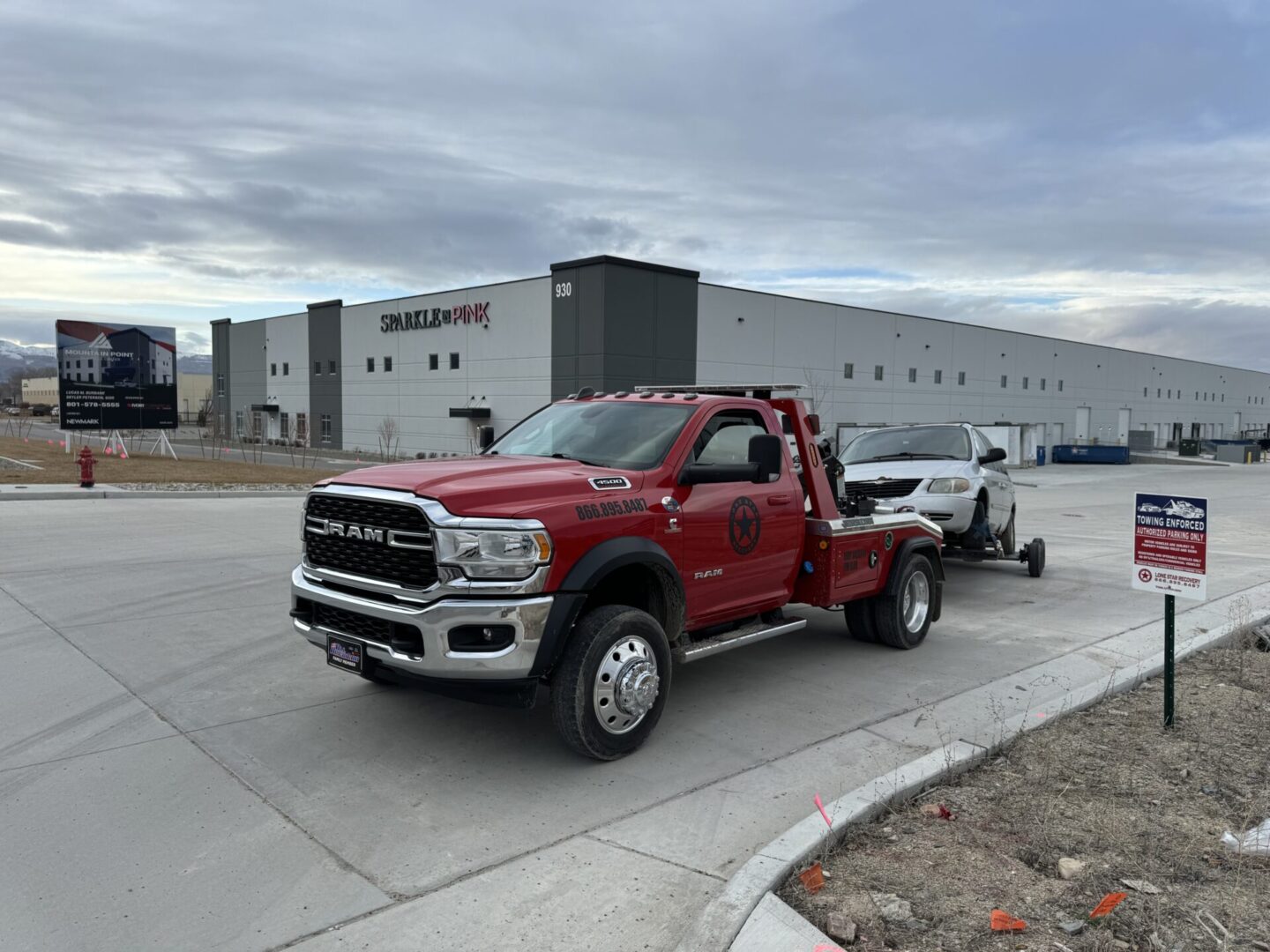 A red tow truck is parked in front of a building.